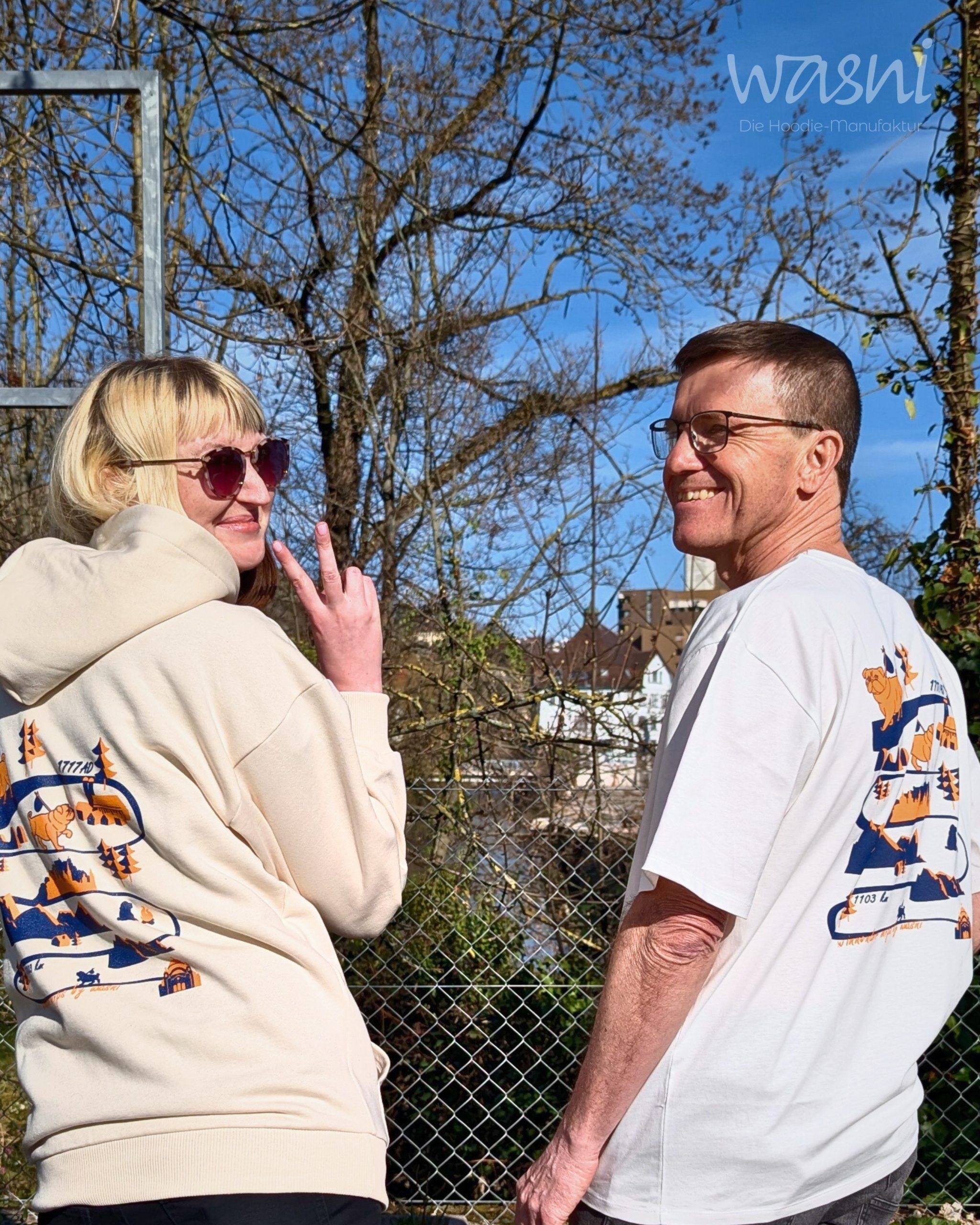 Zwei Personen von hinten tragen Hoodie und T-Shirt mit identischem Mops-Rückenprint in Blau und Orange