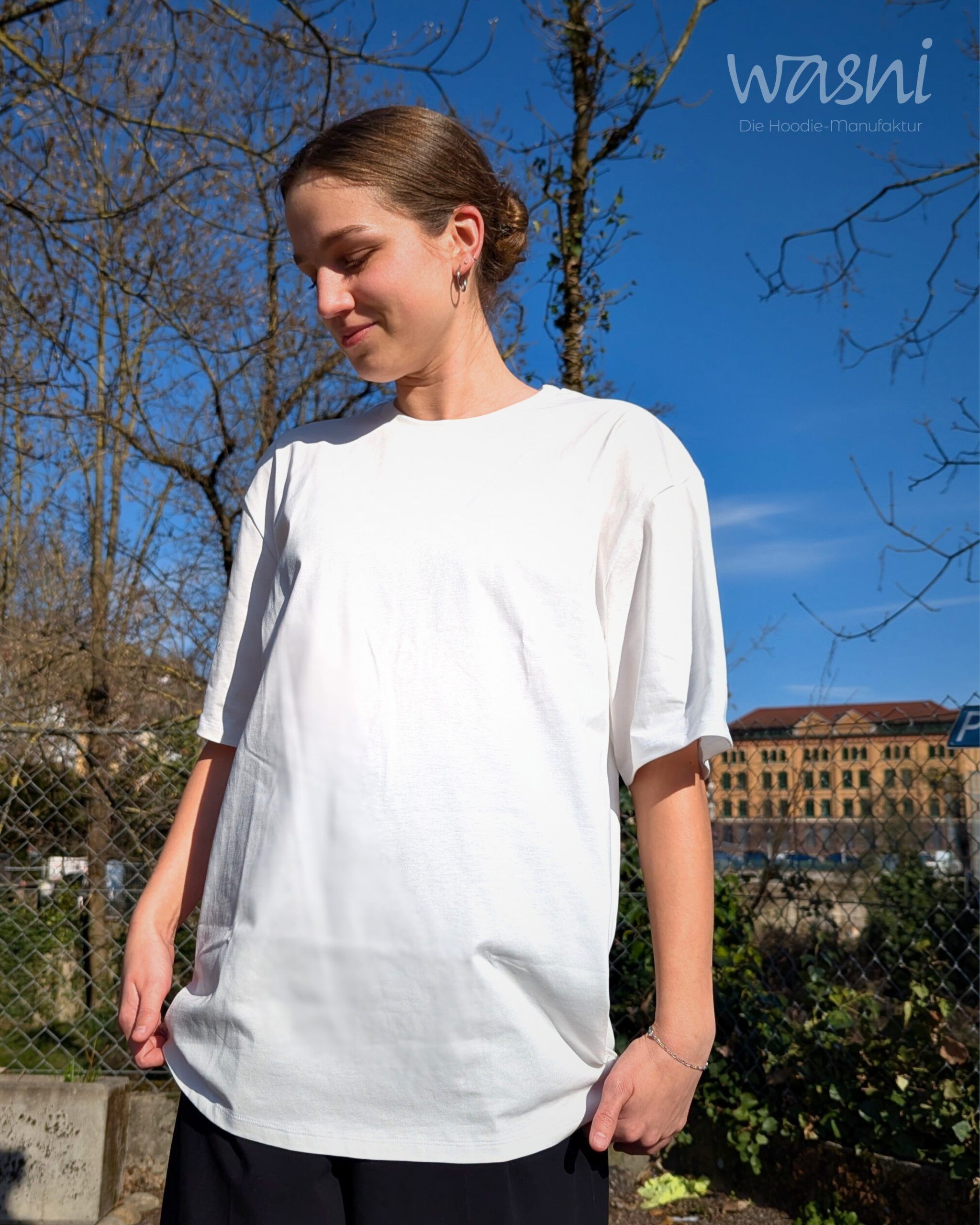 Frau trägt helles T-Shirt von vorne mit lockerem Schnitt bei sonnigem Wetter im Freien