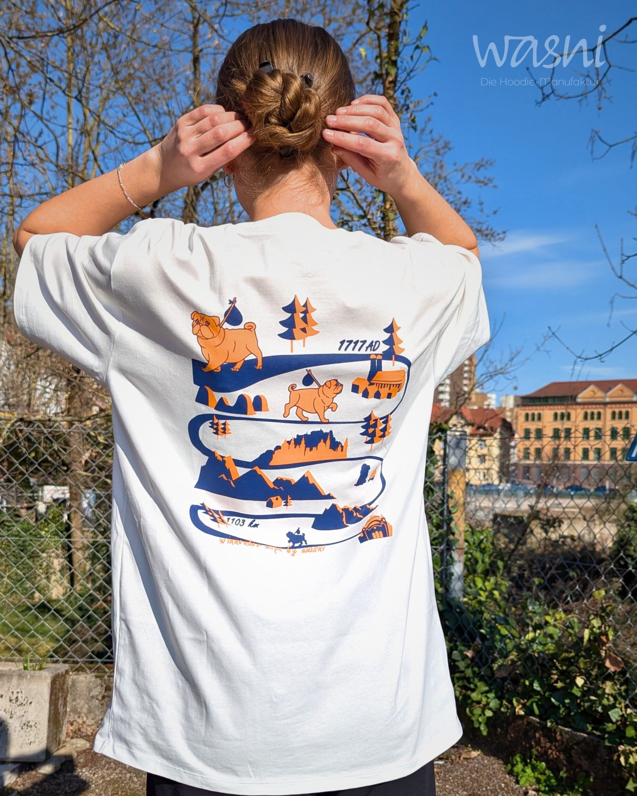 Frau von hinten trägt helles T-Shirt mit großem Mops-Rückenprint und Winnender Mops Motiv